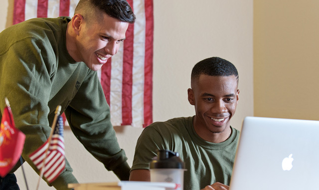 Service members looking at a laptop